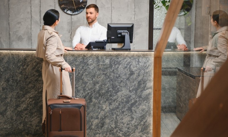 gost stoji za pultom u hotelu